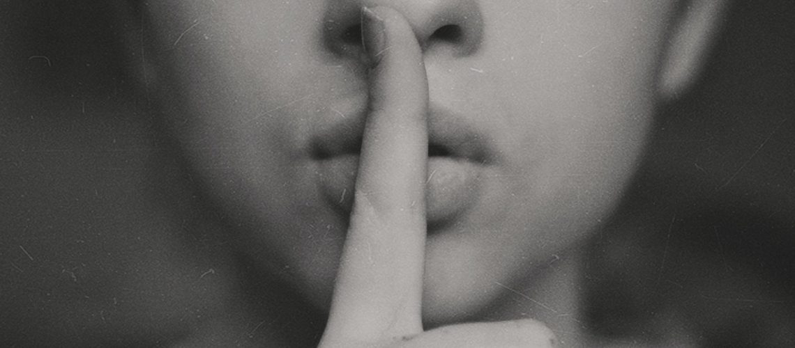 grayscale photo of woman doing silent hand sign